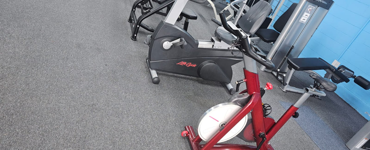 The cardio corner: a spin bike in front of a Life Cycle exercise bike and a pin loaded machine