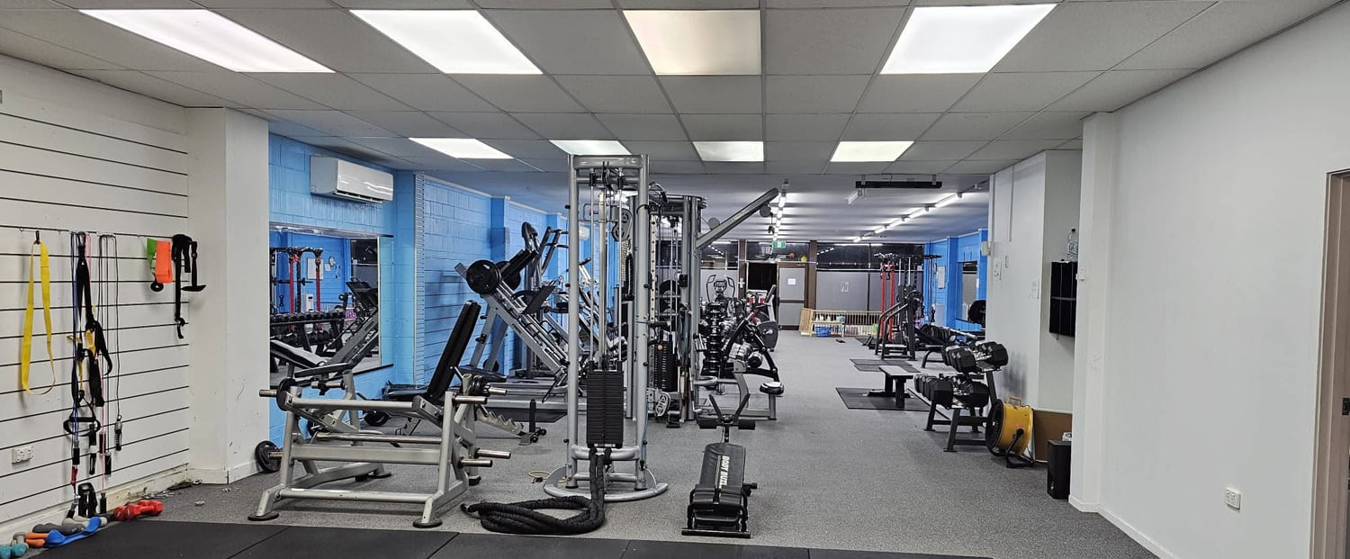 The length of the room from the front doors, with the slat wall of straps and bands on the left and the machines running away down the right