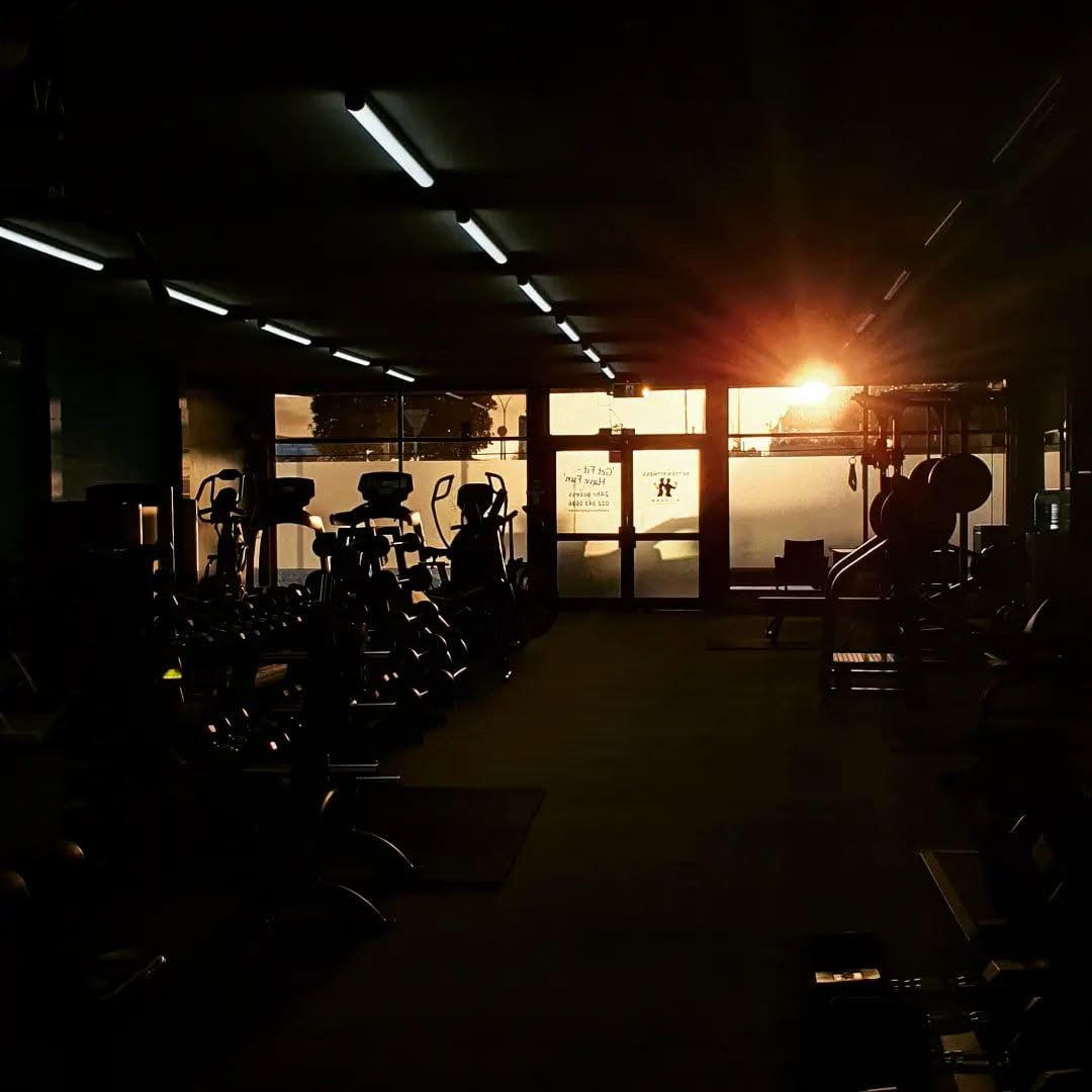 Sunrise coming through the front doors of Better Fitness Putāruru, with the cardio machines in silhouette
